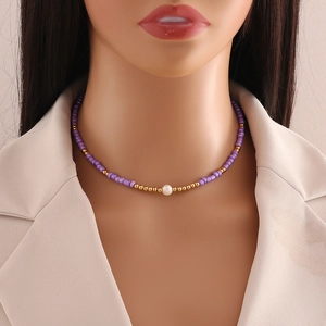 Bohemian seed bead necklace with purple cylinders and white pearl worn by a model