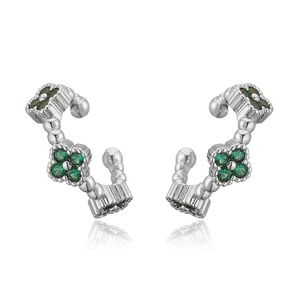 Detail view of silver clover ear bone clips with green crystals on a white background
