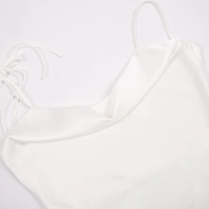 Détail de la robe en satin blanc à col bénitier avec nœud délicat sur l'épaule
