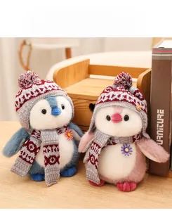Detail of plush penguin toys with knit hats and scarves on a cozy wooden desk