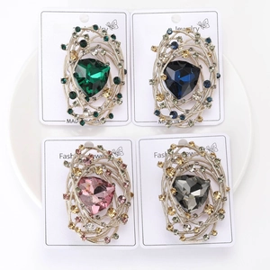Detailed close-up of bird nest style brooches with colorful rhinestones and faceted gems