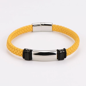 Detail of a bright yellow braided leather bracelet featuring a silver stainless steel magnetic clasp