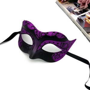 Detail of purple and black Venetian lace mask with glitter texture and silk ribbons