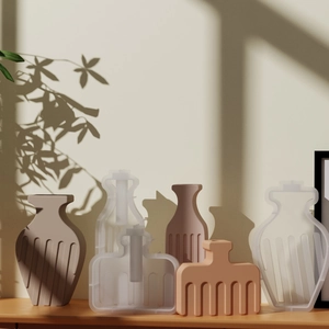 Détail des moules en silicone pour vases rayés et vases finis en résine aux tons terre