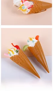 Makro-Detail des künstlichen Eiswaffel-Anhängers mit Sahne und Kirsch-Deko