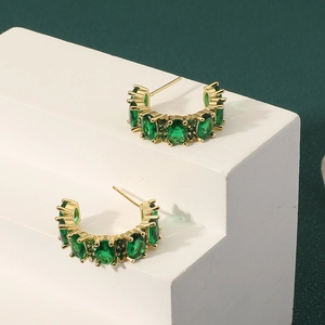 French vintage gold C-shape hoop earrings with emerald zircons on white display stand