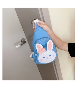 Detail of blue canvas kids chest bag featuring a cute white rabbit with pink sequins