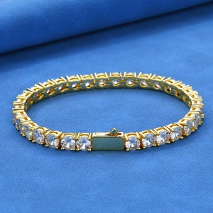 Macro view of gold tennis bracelet with brilliant-cut cubic zirconia on blue velvet
