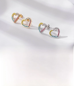 Close-up of heart-shaped titanium steel studs with rainbow cubic zirconia inlay