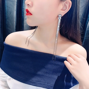 Close-up of elegant silver tassel earrings with crystal fringe worn by model