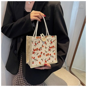 Close-up of vintage floral canvas tote with jute side panels and woven rope handle