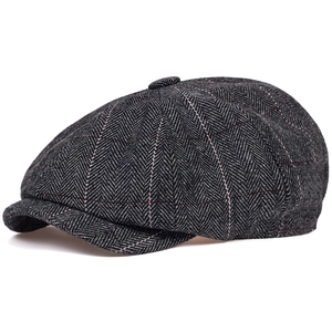 Close-up of herringbone pattern wool newsboy cap with subtle red grid texture