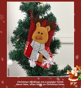 Close-up of red burlap Christmas stocking with a 3D reindeer doll on a festive tree
