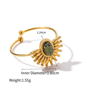 Detail shot of vintage gold ring with green natural stone and radial sunburst pattern