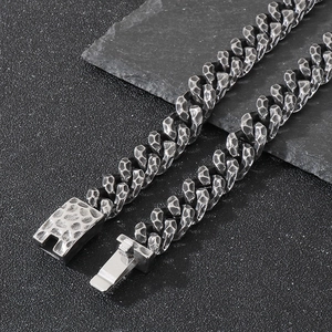 Detail of hammered texture on vintage steel Cuban chain necklace over black rock