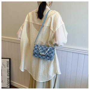 Sac bandoulière en denim bleu avec motif damier et détails à franges sur l'épaule