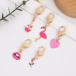 Five-piece set of pink enamel charms with guitar, flamingo, heart and lips on gold clasps