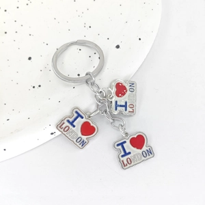 British style silver keychain with three I Love London enamel heart charms on ceramic tray