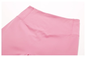 Detail shot of pink high-waist yoga leggings showing flatlock seams and soft matte fabric