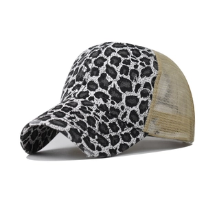 Detail of leopard print fabric with distressed edges and khaki mesh on trucker cap