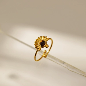 Detailed macro view of gold sunflower ring featuring a brown gemstone and adjustable band