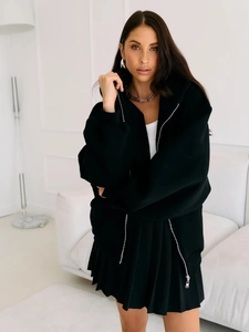 Detail of a black oversized zip-up hoodie with a double-ended zipper and drawstring hood