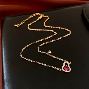 Macro detail of gold-plated wulu necklace with red gemstone and sparkling zircons