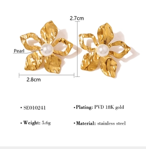 Detail view of flower earrings featuring white pearls and 18K gold plated stainless steel