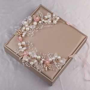 Exquisite Blumenkrone aus Golddraht mit weißen Perlen und rosa Blüten auf Geschenkbox