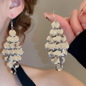 Macro detail of silver sequin disc tassel earrings with a multi-layer metallic fringe drop