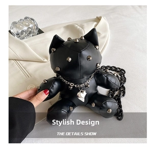 Detail of black cat cross-body bag with silver studs and heart pendant decoration
