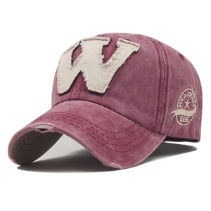 Detail of vintage washed cotton baseball cap featuring embroidered W patch and side badge