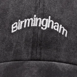 Close-up of Birmingham 3D embroidery on a charcoal grey washed cotton baseball cap