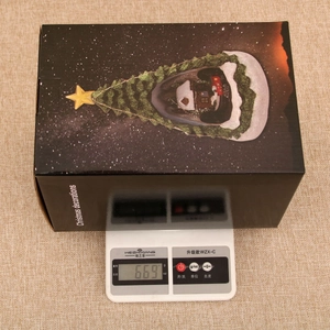 Christmas musical train box weight verification on scales showing 669 grams
