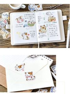 Detail of cute cartoon cat stickers applied on a diary and envelope for DIY decoration