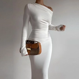 Détail de l'élégant fronçage à la taille d'une robe longue blanche à manche asymétrique