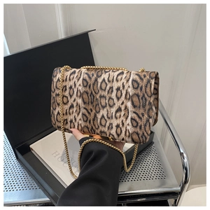 Detail of leopard print flap bag featuring a golden chain strap and magnetic metal closure