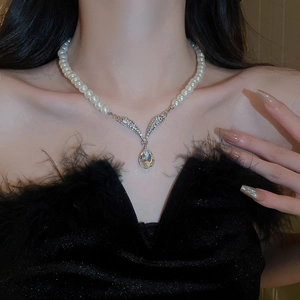 Close-up of pearl necklace with a silver diamond-encrusted teardrop crystal pendant