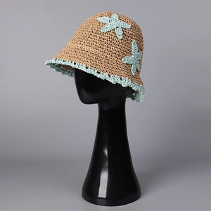 Detail of handmade straw bucket hat featuring blue crochet star and scalloped lace edge