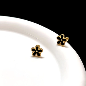 Detailed view of 3D gold-plated flower earrings with black enamel petals and metal frame