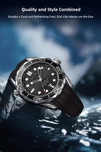 Close-up of dive watch with black wave dial on wet rocks with splashing water