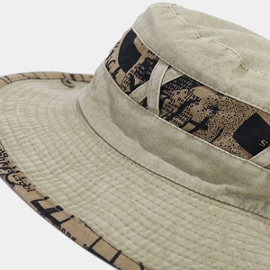 Close-up of khaki canvas bucket hat featuring vintage brass snap and printed trim band