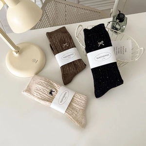 Three pairs of knit crew socks with bow embroidery in beige, coffee, and charcoal grey