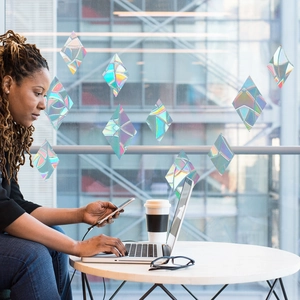 Diamond-shaped holographic prism window stickers reflecting rainbow light in office