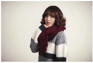 Detail of burgundy cashmere feel scarf showing fringe edges and soft knit texture
