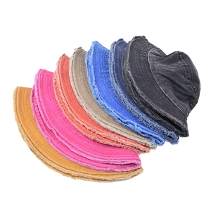 Frayed edge washed cotton bucket hats in seven colors displayed in a fan arrangement