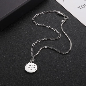 Silver round coin pendant necklace with paperclip chain shown from a 45-degree angle