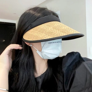 Close-up of the woven straw brim and black textile headband on a sun visor hat