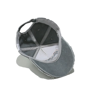 Detail view of distressed grey baseball cap interior showing sewing lines and metal buckle