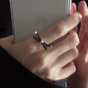 Detailed shot of beaded bow ring with black beads and silver metal accent bead